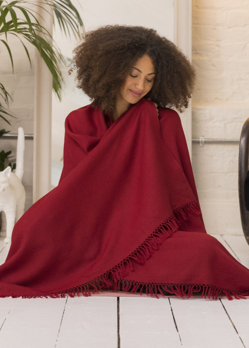 A woman wearing a vibrant red meditation shawl, handwoven in 100% merino wool by likemary.